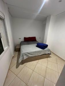 a small bedroom with a bed with blue sheets on it at Apparemment BAHRA in Taza