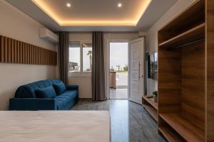 a living room with a blue sofa and a couch at OLYMPIADA GIRNI Suites in Paralia Katerinis +119 photos
