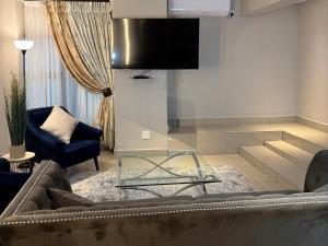 ein Wohnzimmer mit Sofa und Glastisch in der Unterkunft Liquid Blue Guesthouse in Louis Trichardt