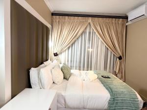 ein Schlafzimmer mit einem weißen Bett vor einem Fenster in der Unterkunft Liquid Blue Guesthouse in Louis Trichardt + 127 Fotos