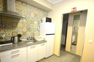 a kitchen with a sink and a white refrigerator at Stay DP Setúbal in Setúbal