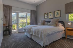 a bedroom with a bed and a large window at Silvermist Organic Wine Estate in Cape Town +67 photos