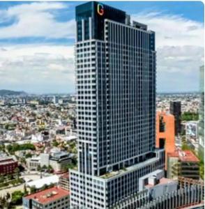 a tall building with a sign on top of it at Stylish Loft for 4 Reforma CDMX Ideal Long Stay in Mexico City
