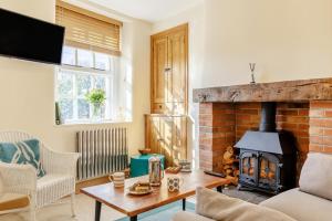 a living room with a brick fireplace and a table at 3 Bed in Tideswell oc-w39004 in Tideswell