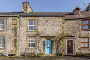 an old stone house with a blue door at 3 Bed in Tideswell oc-w39004 in Tideswell
