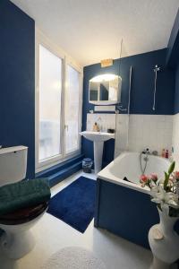 a blue bathroom with a tub and a sink at Gîte de Linéa Centre de Loches in Loches