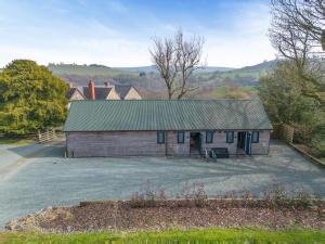 a large wooden barn with a green roof at 1 Bed in Minsterley oc-s38642 in Minsterley