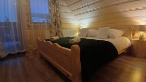 a bedroom with a bed with a teddy bear on it at Tatra West Farm in Dzianisz