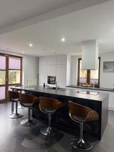 a kitchen with a large black counter with bar chairs at TOBI-pokoje gościnne in Łeba