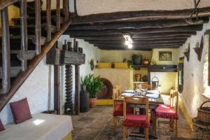 a dining room with a table and red chairs at Complejo El Alambique in Algatocín