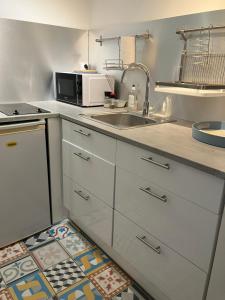 a kitchen with a sink and a microwave at La cerisaie in Montpellier