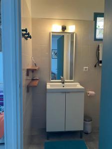 a bathroom with a white sink and a mirror at La cerisaie in Montpellier +8 photos