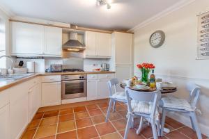a kitchen with white cabinets and a table and chairs at 2 Bed in Reydon oc-s39034 in Reydon +17 photos