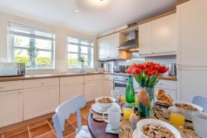 a kitchen with a table with food and flowers on it at 2 Bed in Reydon oc-s39034 in Reydon