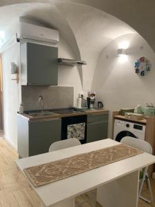 a kitchen with a sink and a table with chairs at F&F Room in Sassari