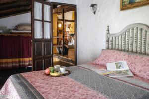 a bed with a plate of fruit on it at Complejo El Alambique in Algatocín