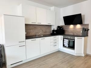 a white kitchen with white cabinets and a sink at Feel like Home 8 in Biberach an der Riß