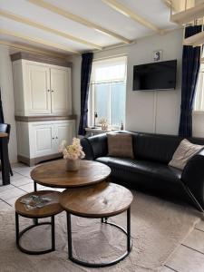a living room with a black couch and a table at Appartementen Koets in Biggekerke