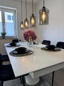 a dining room table with glasses and a vase of flowers at Feel like Home 8 in Biberach an der Riß