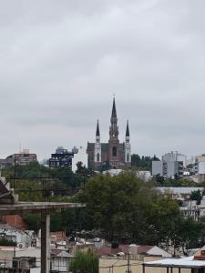 a view of a city with a church in the background at Balcón de Lourdes in Santos Lugares