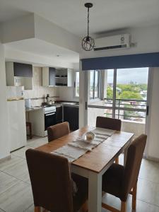 a kitchen with a wooden table with chairs and a dining room at Balcón de Lourdes in Santos Lugares