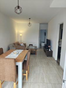 a living room with a table and a couch at Balcón de Lourdes in Santos Lugares +5 photos