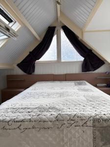 a bed in a room with a large window at Appartementen Koets in Biggekerke