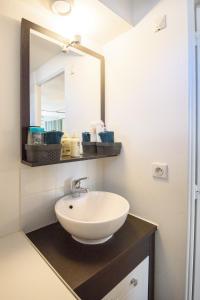 a bathroom with a sink and a mirror at Studio tout confort proche des thermes in Vals-les-Bains +7 photos