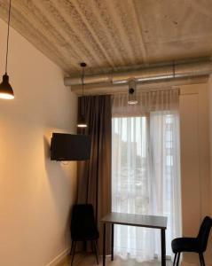 a living room with a table and a window at Apartment Loftas13-6 in Kretinga
