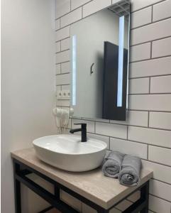 a bathroom with a sink and a mirror and towels at Apartment Loftas13-6 in Kretinga