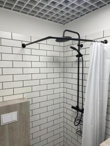 a shower curtain in a bathroom with a white tile wall at Apartment Loftas13-6 in Kretinga