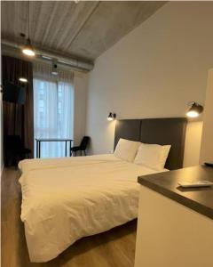 a bedroom with a white bed and a table at Apartment Loftas13-6 in Kretinga