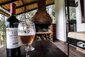 a bottle of wine and a glass on a wooden table at Villa Germana in Paipa
