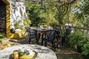 an outdoor table with chairs and fruit on a patio at Complejo El Alambique in Algatocín