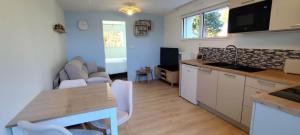 a kitchen and living room with a table and chairs at Île Dumet - Appt T2 cocooning - 2 à 4 pers. - Piscine & Spa in La Turballe