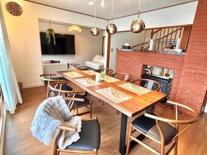 a dining room with a wooden table and chairs at Snoa Kitanomine - スノア キタノミネ - in Furano