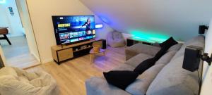 a living room with a couch and a flat screen tv at Île d'Houat - Maison 5ch - 7 à 14 pers. - Piscine & S in La Turballe