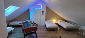 a attic room with two beds and a blue light at Île d'Houat - Maison 5ch - 7 à 14 pers. - Piscine & S in La Turballe