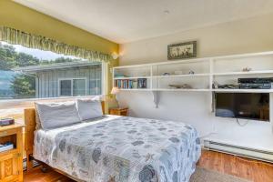 a bedroom with a bed and a tv and a window at Inviting dog-friendly studio with unobstructed ocean views in Bandon +16 photos