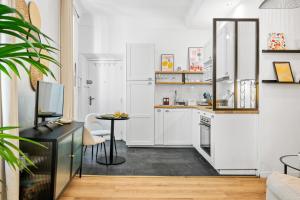 a small kitchen with white cabinets and a table at Sky Lodge - Vieux Nice in Nice