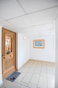 an empty room with a door and a tile floor at Studio tout confort proche des thermes in Vals-les-Bains