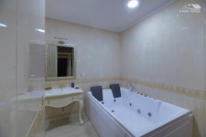 Baño blanco con bañera y lavamanos en Casa Gaçe Hotel, en Korçë