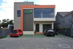 dos autos estacionados en un estacionamiento frente a un edificio en Amaya Suites Hotel en Yogyakarta