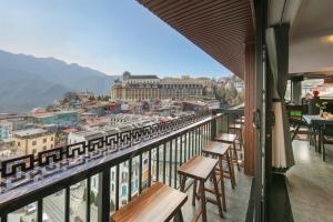 a balcony with wooden tables and chairs and a train at Sapa Horizon Hotel & Skybar in Sapa