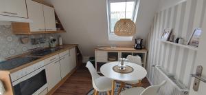 a kitchen with a table and a small table and chairs at Uns Lüttje in Norden