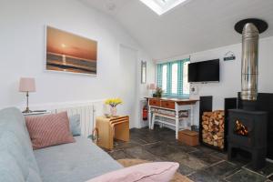 a living room with a couch and a fireplace at Smugglers Cottage in Tintagel