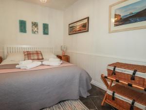a bedroom with a bed with towels on it at Smugglers Cottage in Tintagel
