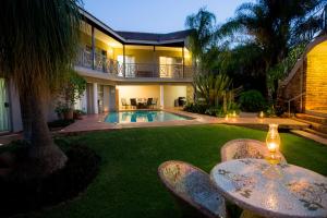 a yard with a house and a swimming pool at Loerie Guesthouse in Hoedspruit