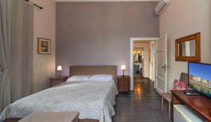 a bedroom with a bed and a flat screen tv at B&B Villa Regina in Pisa +56 photos