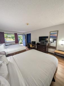 a hotel room with two beds and a mirror at Garden Inn Adairsville in Adairsville